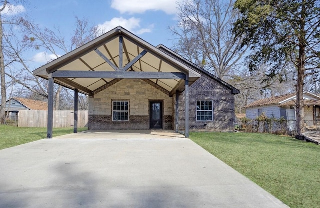 view of front of home featuring a front yard, concrete driveway, and brick siding