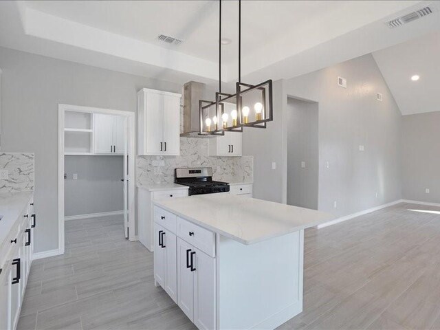 kitchen with white cabinetry, visible vents, decorative backsplash, and stainless steel stove