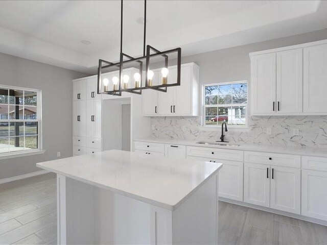 kitchen with white cabinets, a sink, and backsplash