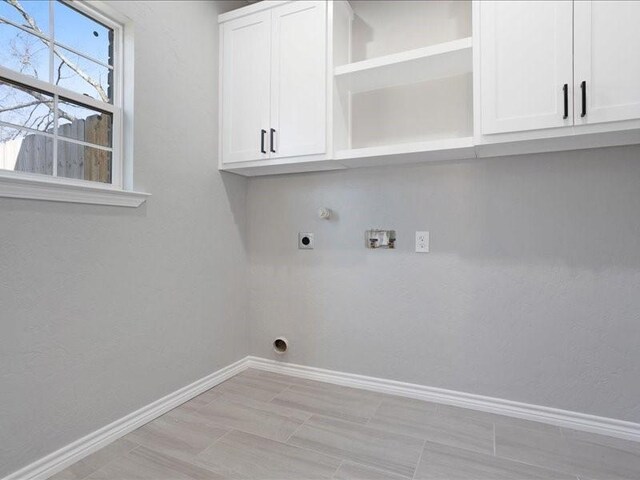 laundry room with washer hookup, cabinet space, baseboards, and electric dryer hookup