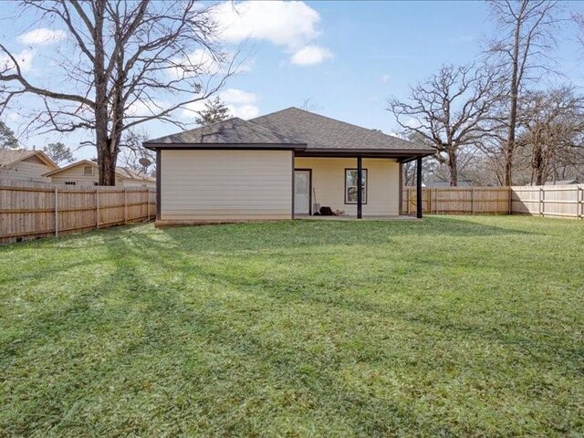 back of house featuring a lawn and a fenced backyard