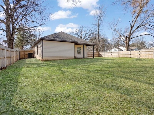 view of yard with a fenced backyard and central AC