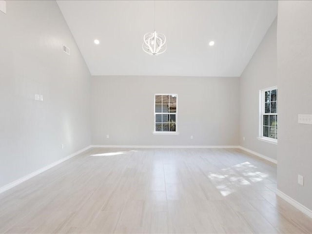 spare room featuring baseboards, a chandelier, light wood-type flooring, high vaulted ceiling, and recessed lighting