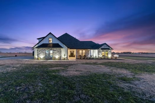 modern farmhouse style home featuring a lawn