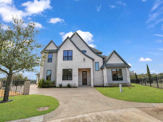 view of front of house with brick siding, fence, and a front yard