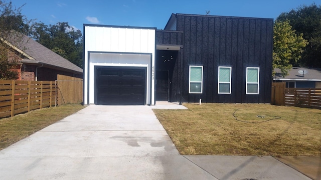 view of front facade with driveway, a garage, fence, a front lawn, and board and batten siding