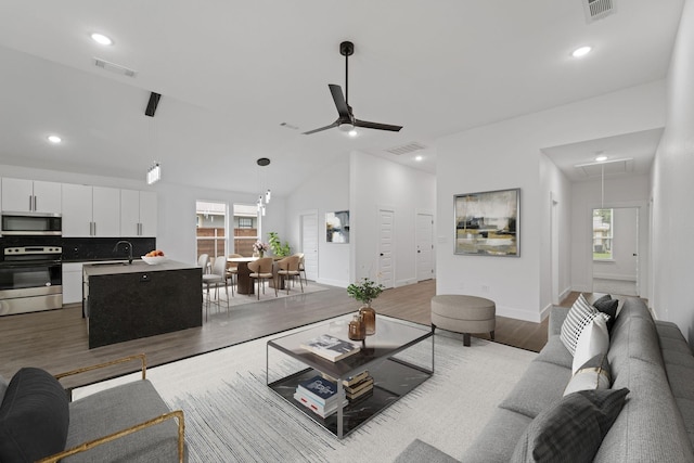 living room with attic access, visible vents, and wood finished floors