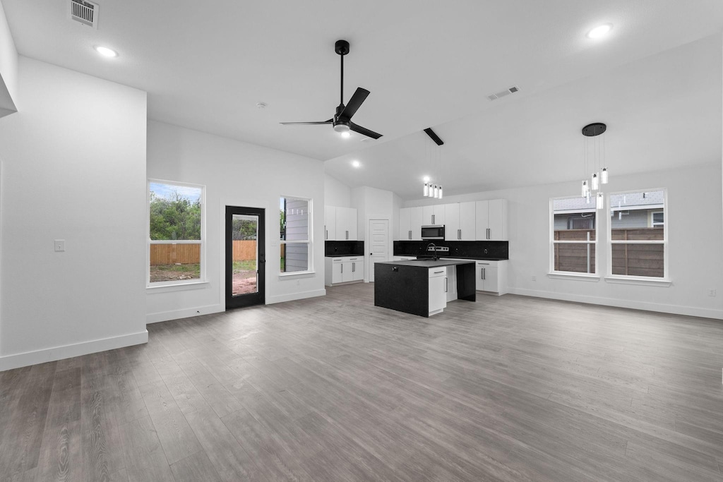 kitchen with visible vents, stainless steel microwave, and open floor plan