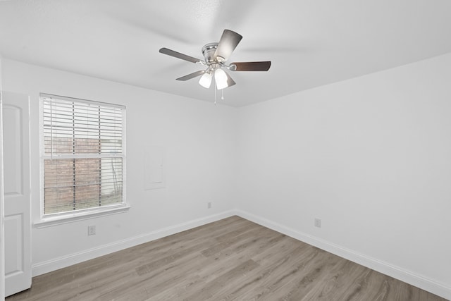 empty room with ceiling fan, light wood-style flooring, and baseboards