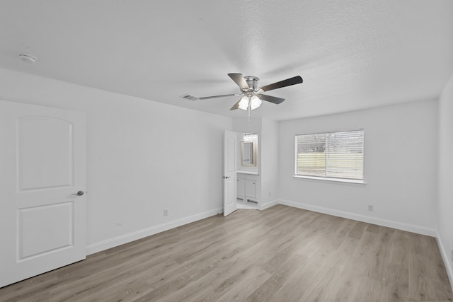 unfurnished room with a ceiling fan, light wood-type flooring, a textured ceiling, and baseboards