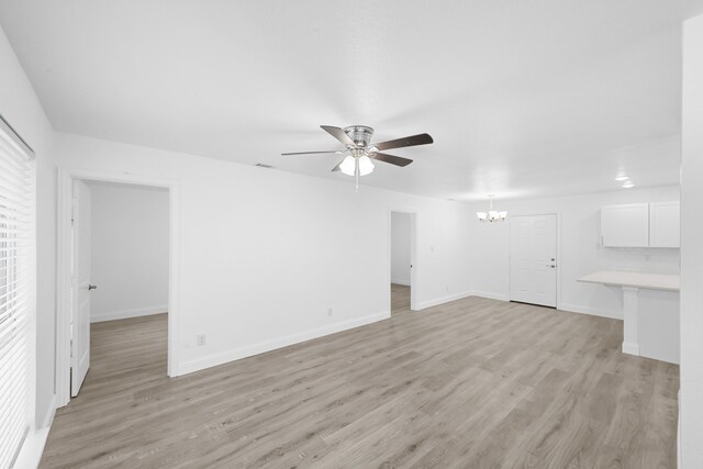819 Netherland Dr, Arlington, TX 76017 - unfurnished living room with a chandelier, ceiling fan, light wood-style flooring, and baseboards