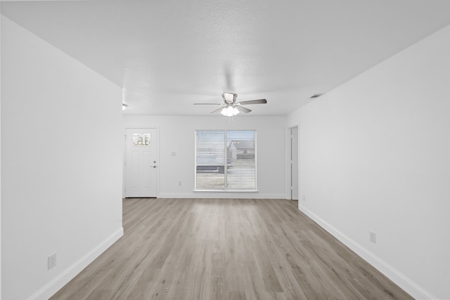 819 Netherland Dr, Arlington, TX 76017 - unfurnished living room with a ceiling fan, light wood finished floors, and baseboards