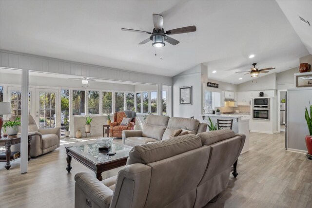 living area with light wood-style floors, recessed lighting, vaulted ceiling, and ceiling fan