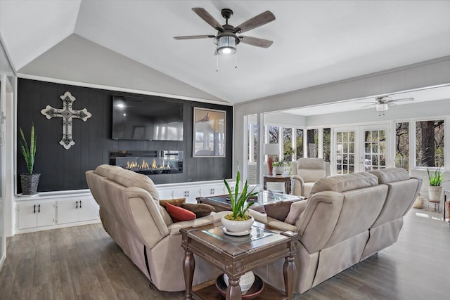 living area with vaulted ceiling, wood finished floors, and a glass covered fireplace