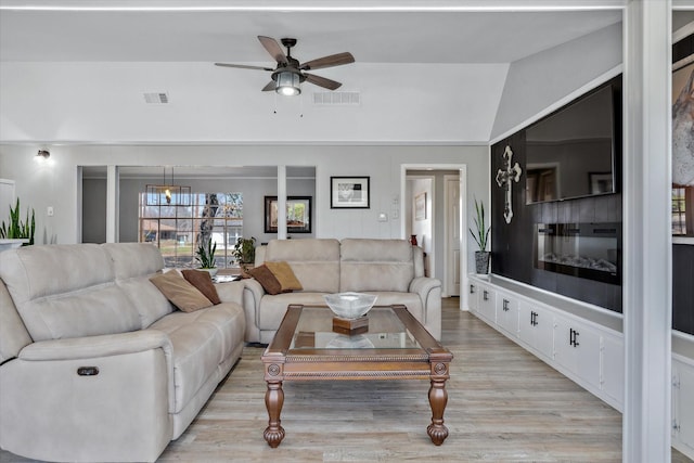 living area featuring light wood finished floors, built in features, visible vents, and a ceiling fan