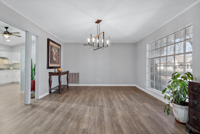 dining room featuring ornamental molding, light wood-type flooring, and visible vents