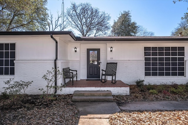 entrance to property featuring brick siding