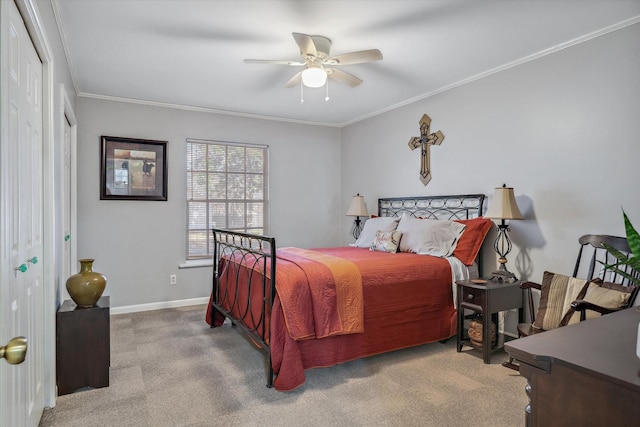 carpeted bedroom featuring a ceiling fan, baseboards, and crown molding