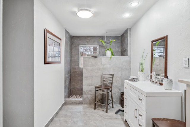 bathroom with plenty of natural light, walk in shower, and vanity