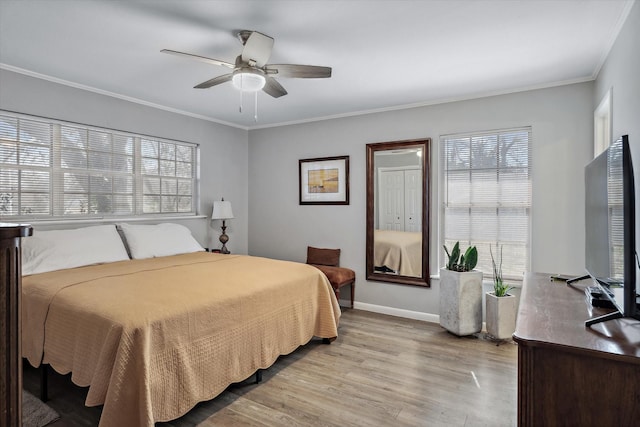 bedroom featuring ornamental molding, light wood-type flooring, baseboards, and a ceiling fan