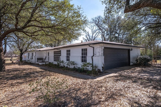 view of property exterior with brick siding, driveway, and an attached garage