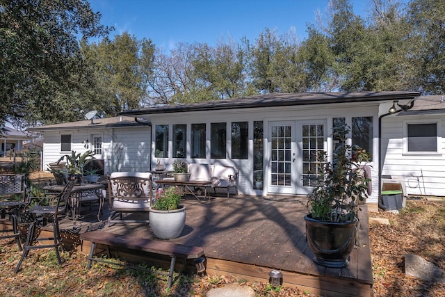 rear view of house featuring a wooden deck and french doors