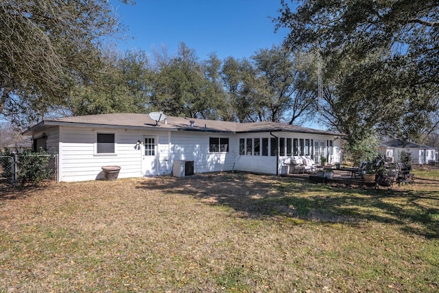 back of property featuring a sunroom, fence, cooling unit, and a lawn