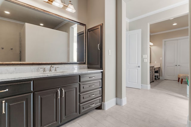 bathroom with ornamental molding, recessed lighting, vanity, and baseboards