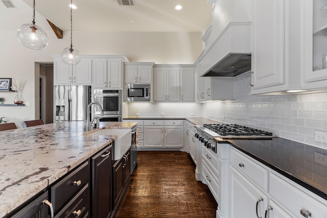 kitchen featuring premium range hood, appliances with stainless steel finishes, a sink, and white cabinetry