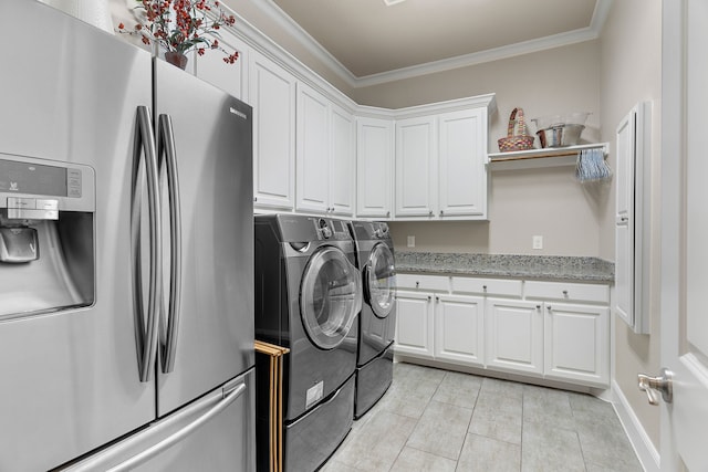 laundry room featuring light tile patterned floors, baseboards, independent washer and dryer, cabinet space, and crown molding