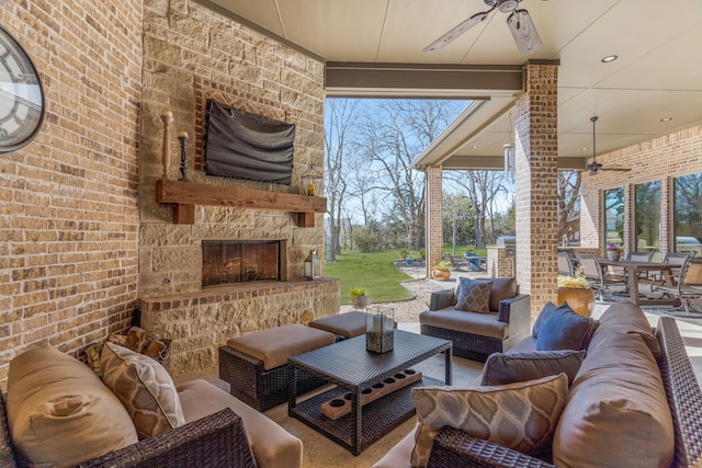 view of patio with ceiling fan, outdoor dining space, and an outdoor living space with a fireplace