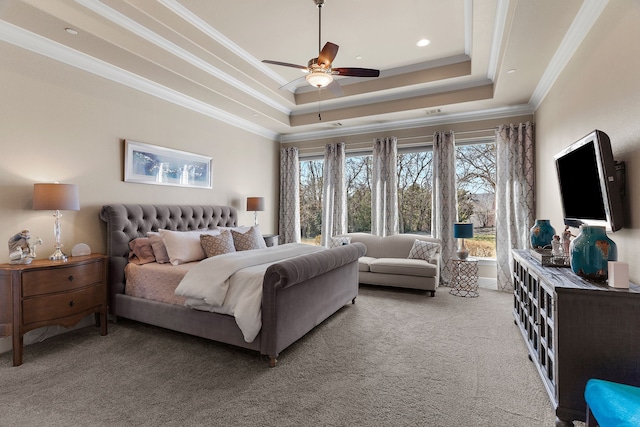 bedroom with carpet, a tray ceiling, ceiling fan, and ornamental molding