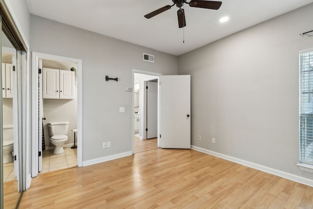 unfurnished bedroom featuring light wood finished floors, baseboards, visible vents, and connected bathroom