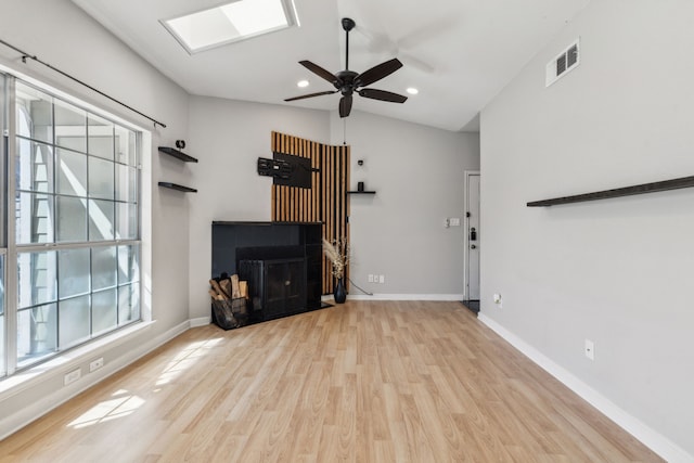 unfurnished living room featuring a fireplace, plenty of natural light, baseboards, and wood finished floors