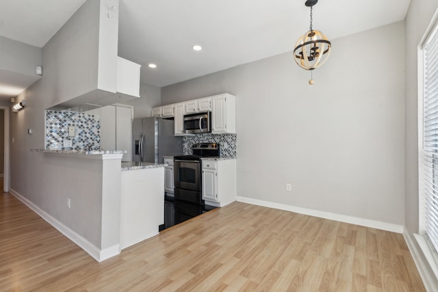 kitchen with light stone counters, tasteful backsplash, appliances with stainless steel finishes, light wood-style floors, and white cabinets