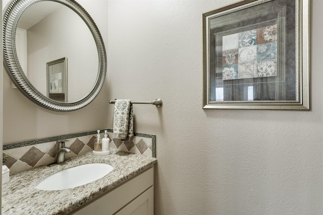 bathroom featuring a textured wall and vanity