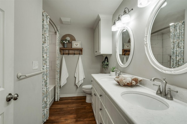 full bath featuring shower / bath combo with shower curtain, a sink, toilet, and wood finished floors