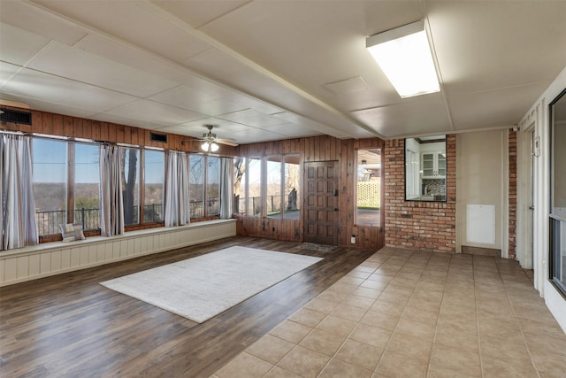 unfurnished sunroom with ceiling fan and visible vents