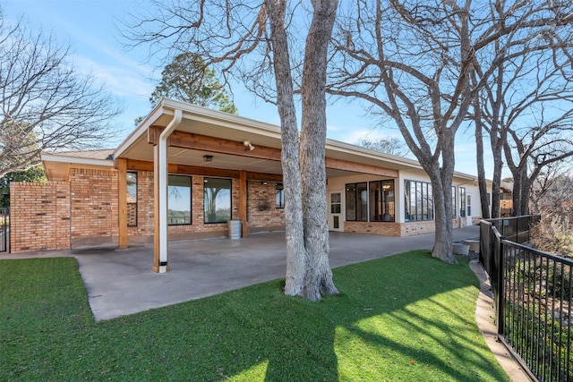 back of house featuring brick siding, fence, and a patio