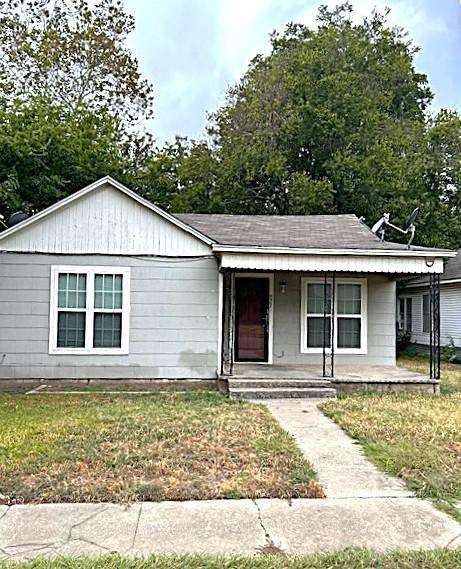 ranch-style home with covered porch and a front yard