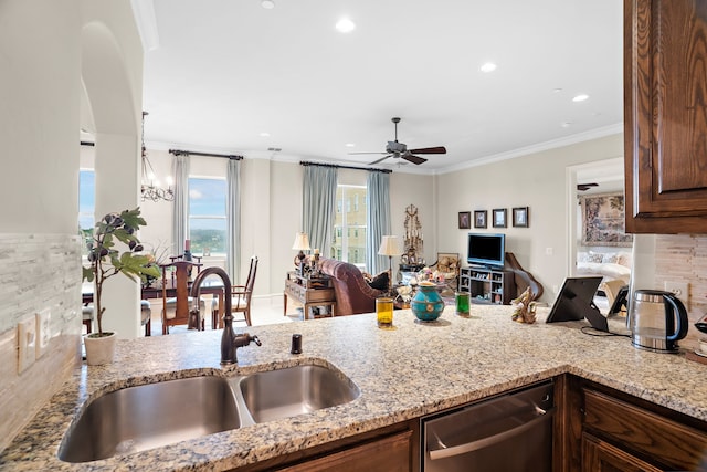 kitchen with dishwasher, open floor plan, light stone countertops, crown molding, and a sink