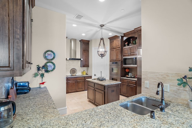 kitchen with black microwave, stainless steel double oven, a sink, wall chimney range hood, and light stone countertops