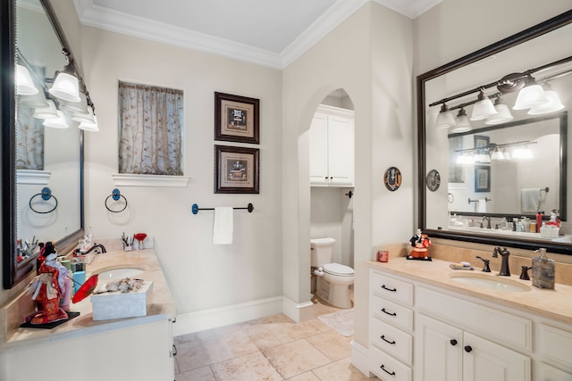 bathroom featuring baseboards, ornamental molding, two vanities, and a sink