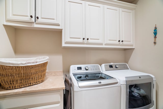 clothes washing area with cabinet space and washer and clothes dryer