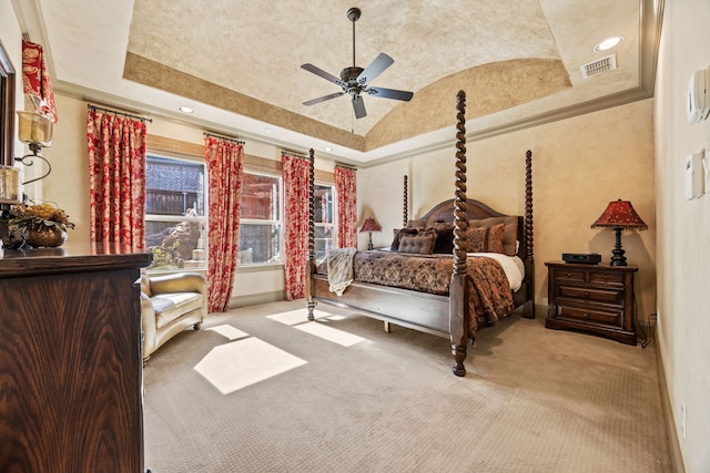 carpeted bedroom with a tray ceiling, visible vents, lofted ceiling, and baseboards