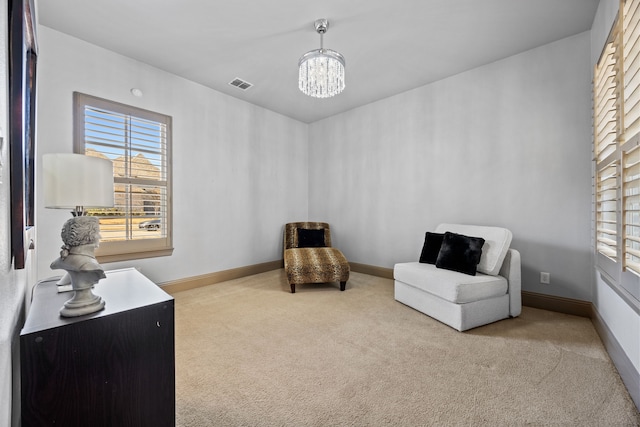 sitting room featuring a chandelier, visible vents, baseboards, and carpet