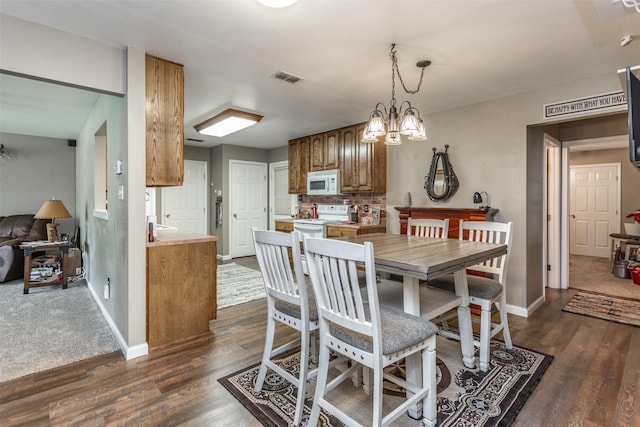 2317 Jodi Ln, Gainesville, TX 76240 - dining space with baseboards, dark wood finished floors, and a chandelier