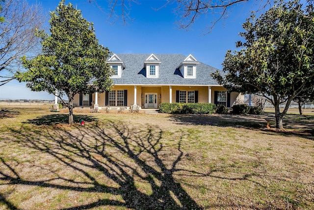 cape cod house featuring a front yard and covered porch