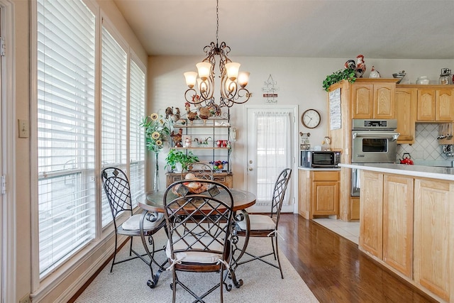 dining space with a chandelier and wood finished floors