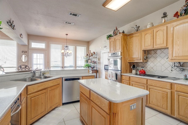 kitchen with a sink, visible vents, light countertops, appliances with stainless steel finishes, and decorative backsplash